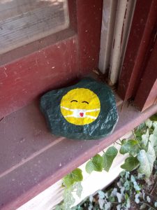 Hand painted rock reminding people to wear masks